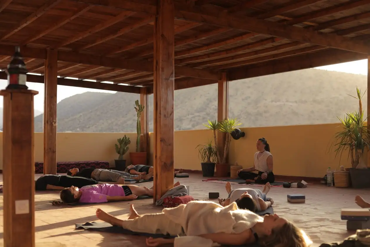 Savasana en la terraza cubierta de la surf house, con las montañas al fondo